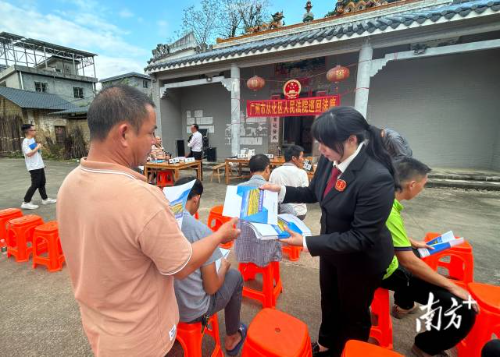 法庭工作人员向村民发放《涉农案件风险防范手册》。通讯员供图
